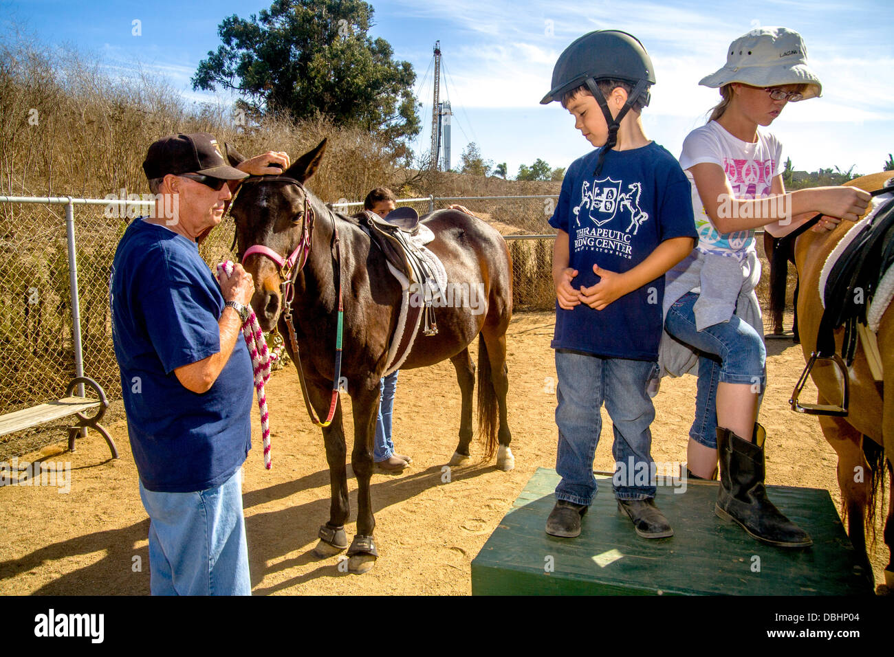 Un ragazzo affilicted con Von Wellebrand malattia e ad alta funzione autismo si prepara a guidare un cavallo come parte di Equitazione terapeutica Foto Stock