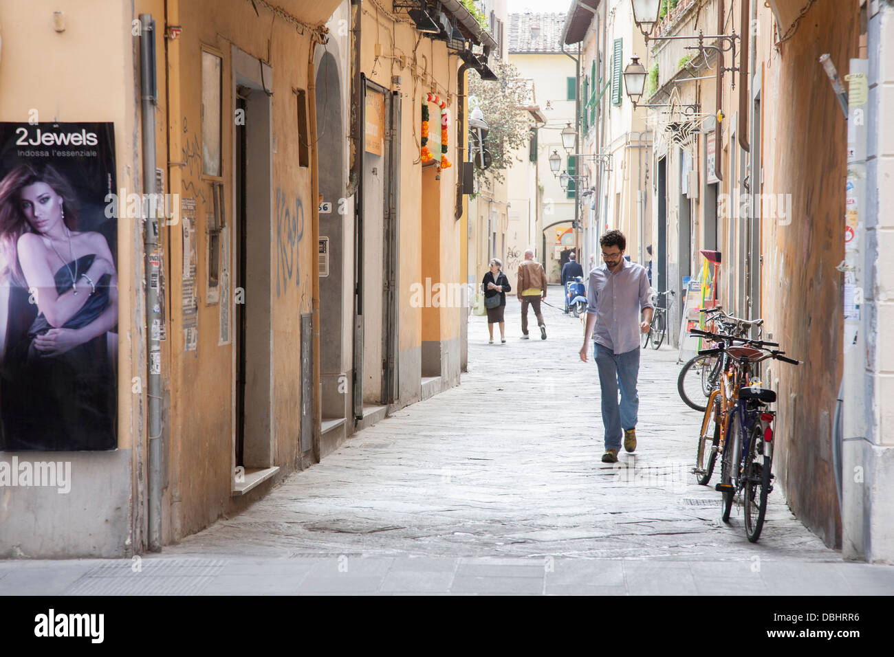 Uomo che cammina nella strada laterale fuori Corso Italia, Pisa; Italia; L'Europa Foto Stock