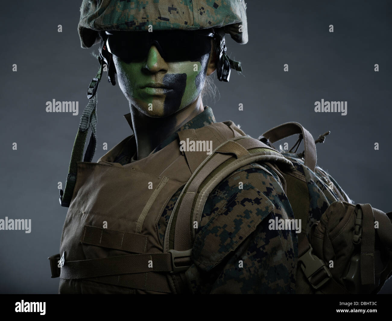 Ritratto di donna United States Marine Corps soldato in uniforme di utilità MARPAT disturbato il camuffamento con camo face paint Foto Stock