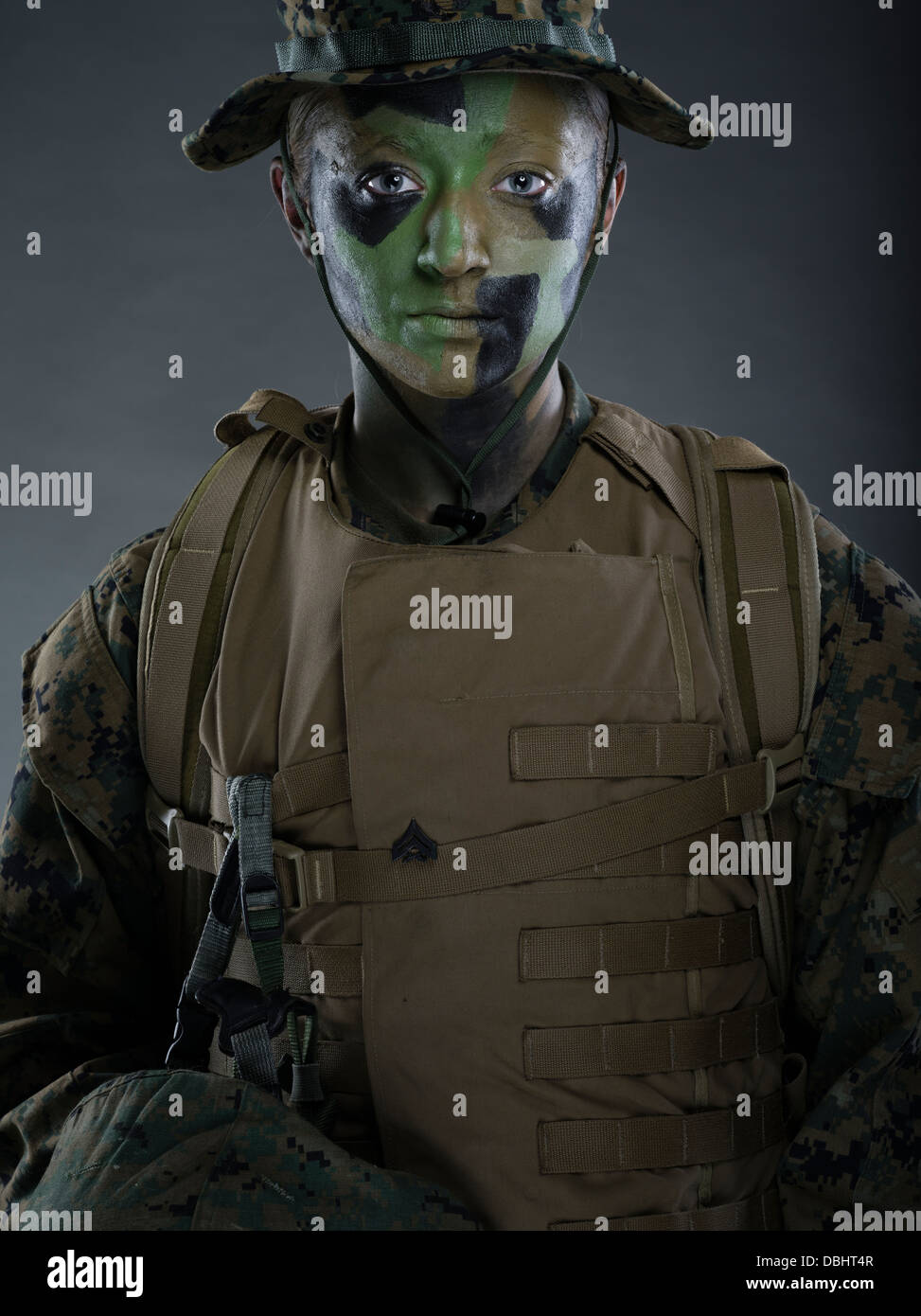 Ritratto di donna United States Marine Corps soldato in uniforme di utilità MARPAT disturbato il camuffamento con camo face paint Foto Stock