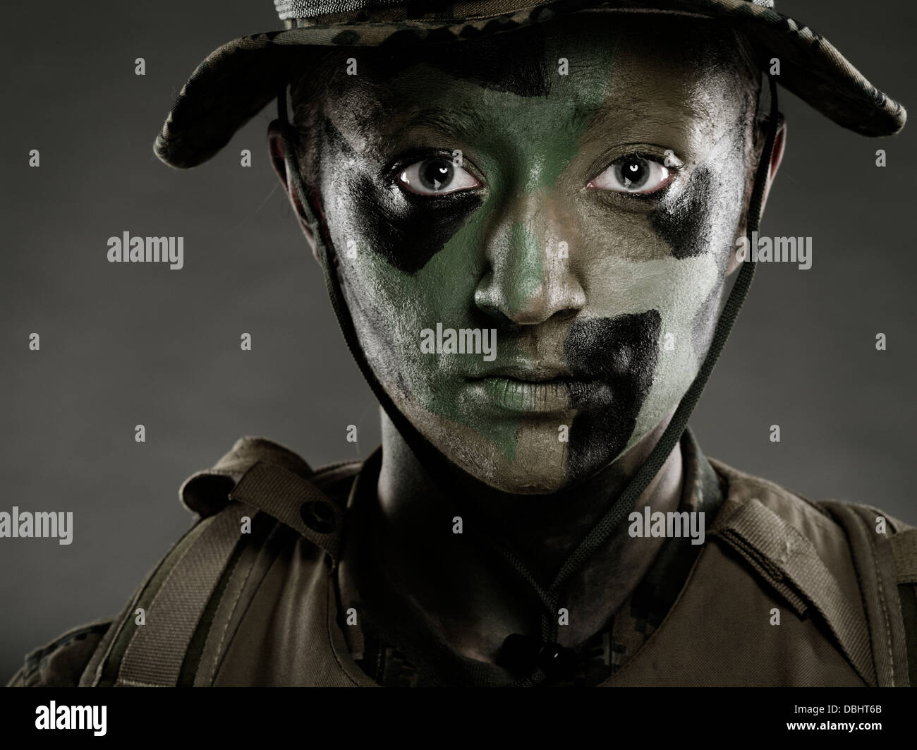 Ritratto di donna United States Marine Corps soldato in uniforme di utilità MARPAT disturbato il camuffamento con camo face paint Foto Stock