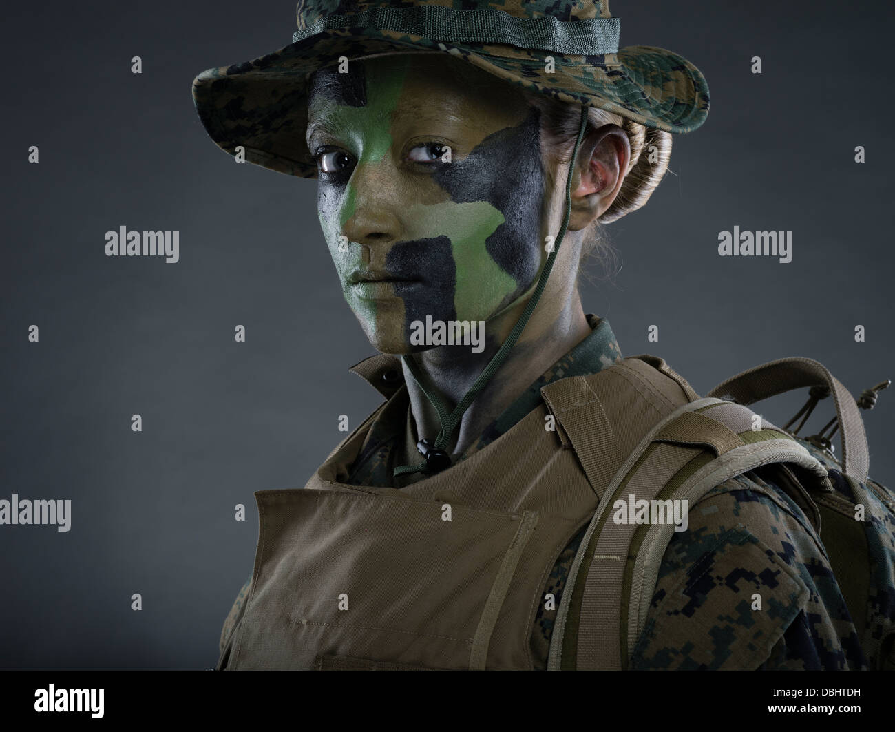 Ritratto di donna United States Marine Corps soldato in uniforme di utilità MARPAT disturbato il camuffamento con camo face paint Foto Stock