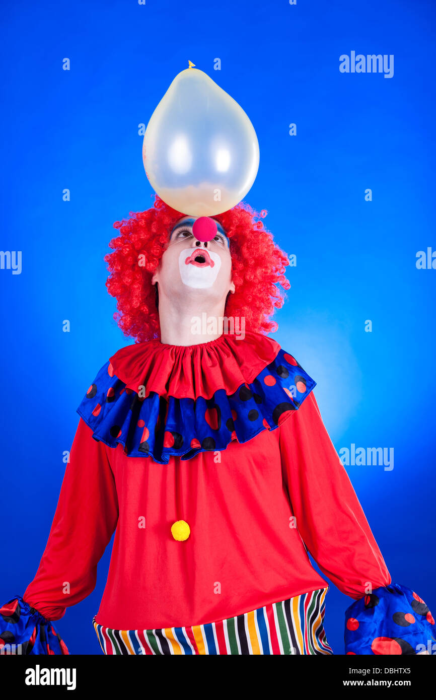 Sorridente clown in studio shot su sfondo blu Foto Stock