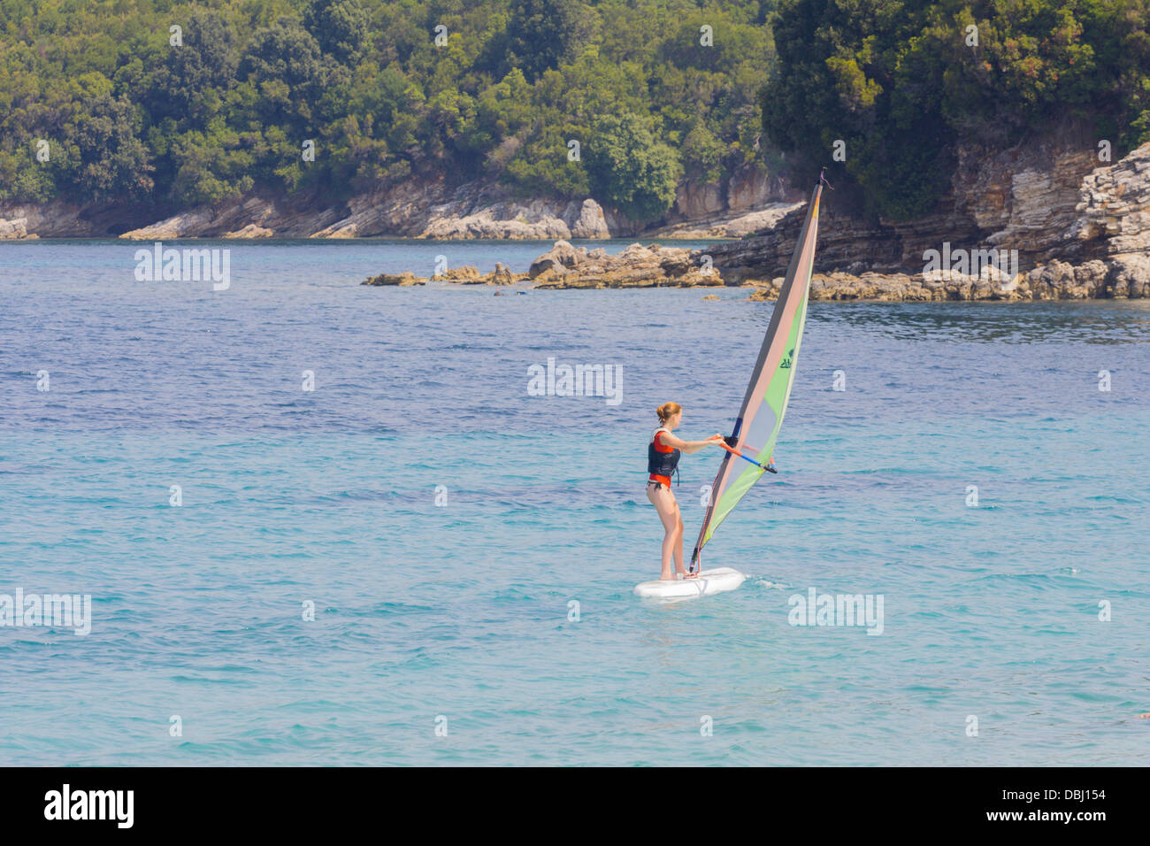 Ragazza adolescente imparare a wind-surf a Avlaki a Corfù Foto Stock