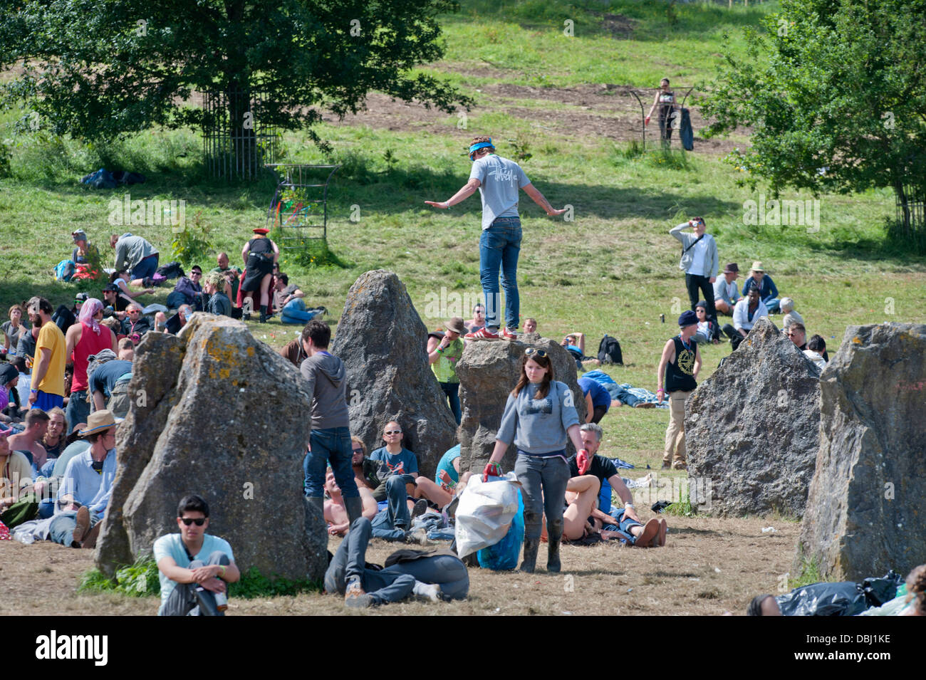 Glastonbury Festival 2013 UK - Uomo in equilibrio su una delle pietre permanente Foto Stock