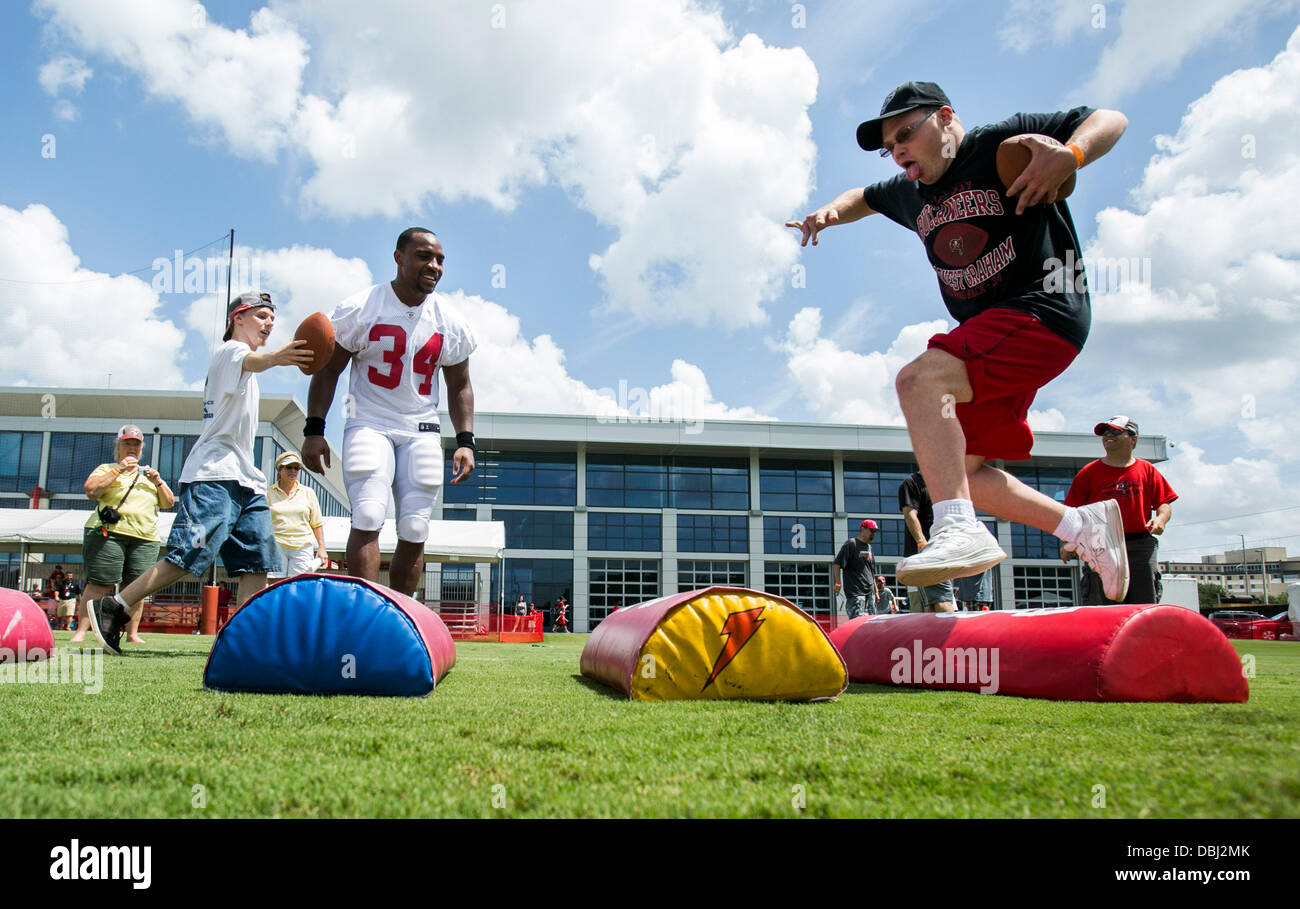 Luglio 31, 2013 - Tampa, Florida, Stati Uniti - Sarà VRAGOVIC | Orari .Gregorio Konrad, 24, destra, ostacoli pad mentre i Bucs' Michael Smith (34) cheers lui su durante il Tampa Bay Buccaneers training camp a uno Buc luogo mercoledì 31 luglio, 2013. Konrad, con il gruppo da Special Olympics Pasco, era uno dei 60 gli atleti degli Special Olympics da Hillsborough, Pinellas, Pasco e Polk contee che correva attraverso le punte con la Bucs alla fine del training camp sessione su mercoledì. (Credito Immagine: © sarà Vragovic/Tampa Bay volte/ZUMAPRESS.com) Foto Stock