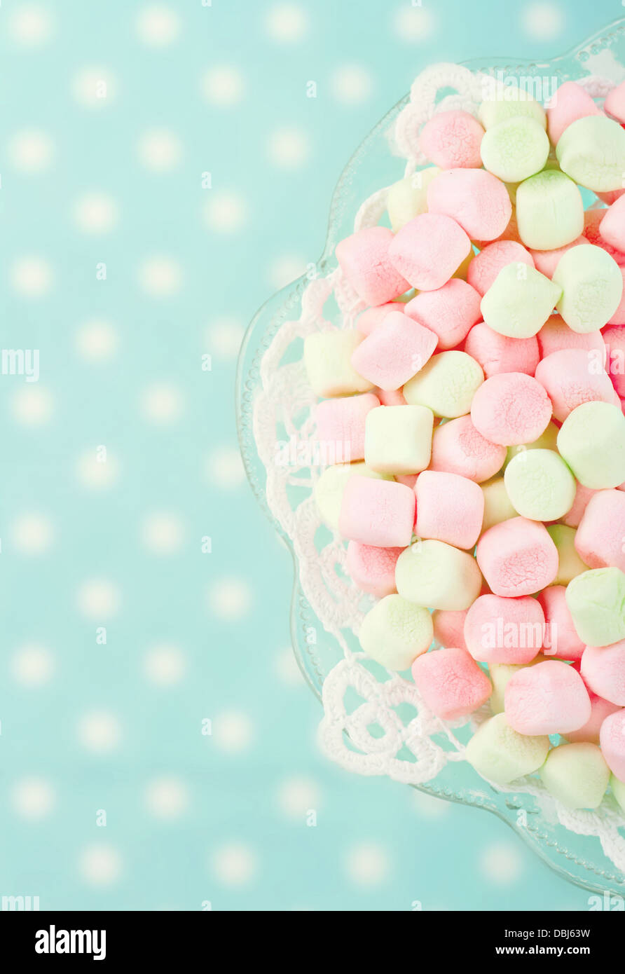 Rosa marshmallows su polkadot blu sfondo sfocato con vintage editing nostalgico Foto Stock