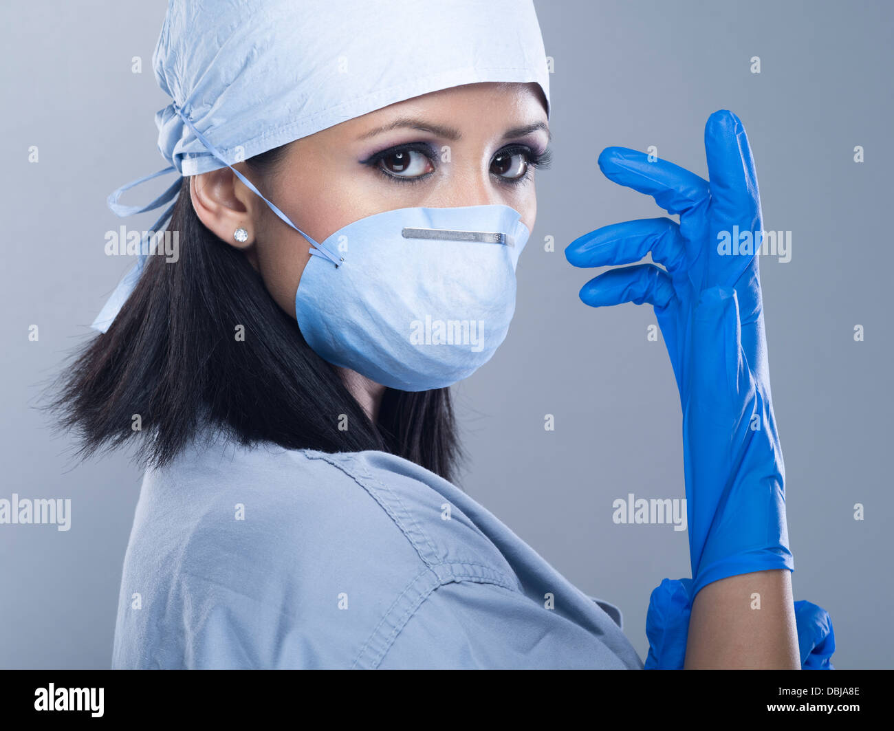Femmina / infermiere Medico Chirurgo / indossando scrubs con guanti e maschera Foto Stock