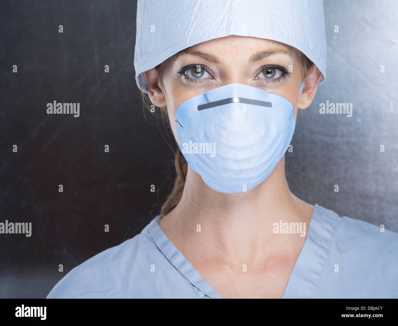 Medic femmina indossando scrub chirurgico il cappuccio e la maschera Foto Stock
