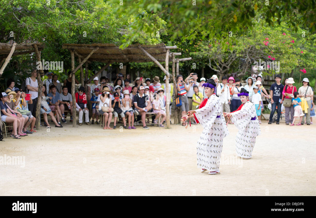 I turisti guarda un tradizionale ryukyu performance di danza a Ryukyu Mura Okinawa in Giappone Foto Stock