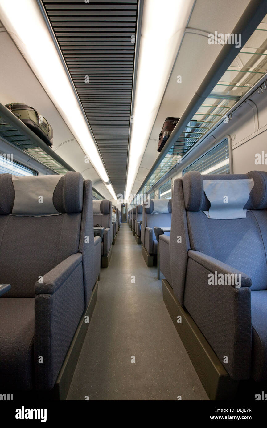 Interno di un vuoto che la cabina prima classe in un moderno treno europeo auto; con lussuose tessuto grigio sedili con appoggiatesta. Foto Stock