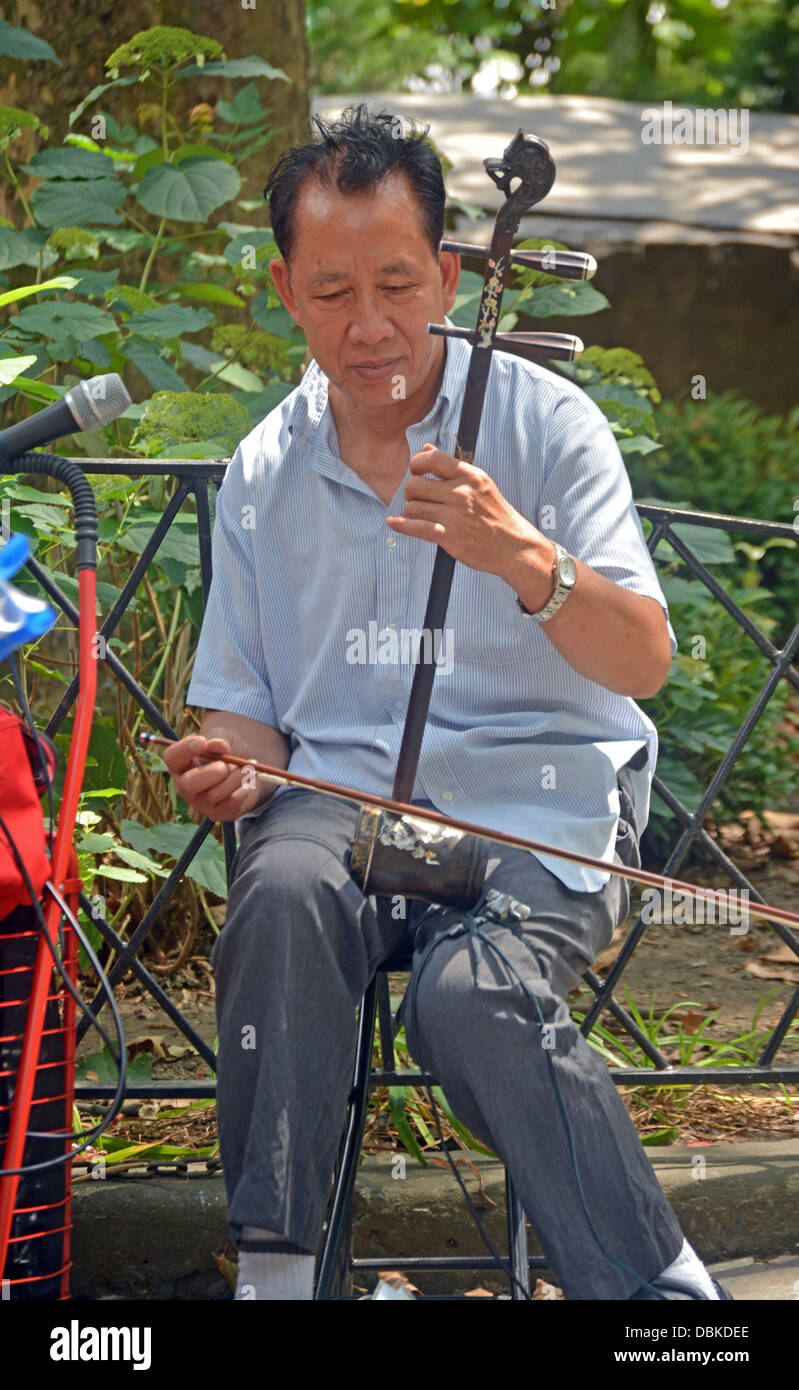 Uomo cinese la riproduzione del erhu e richiedono donazioni in Columbus Park a Chinatown, in New York City. Foto Stock