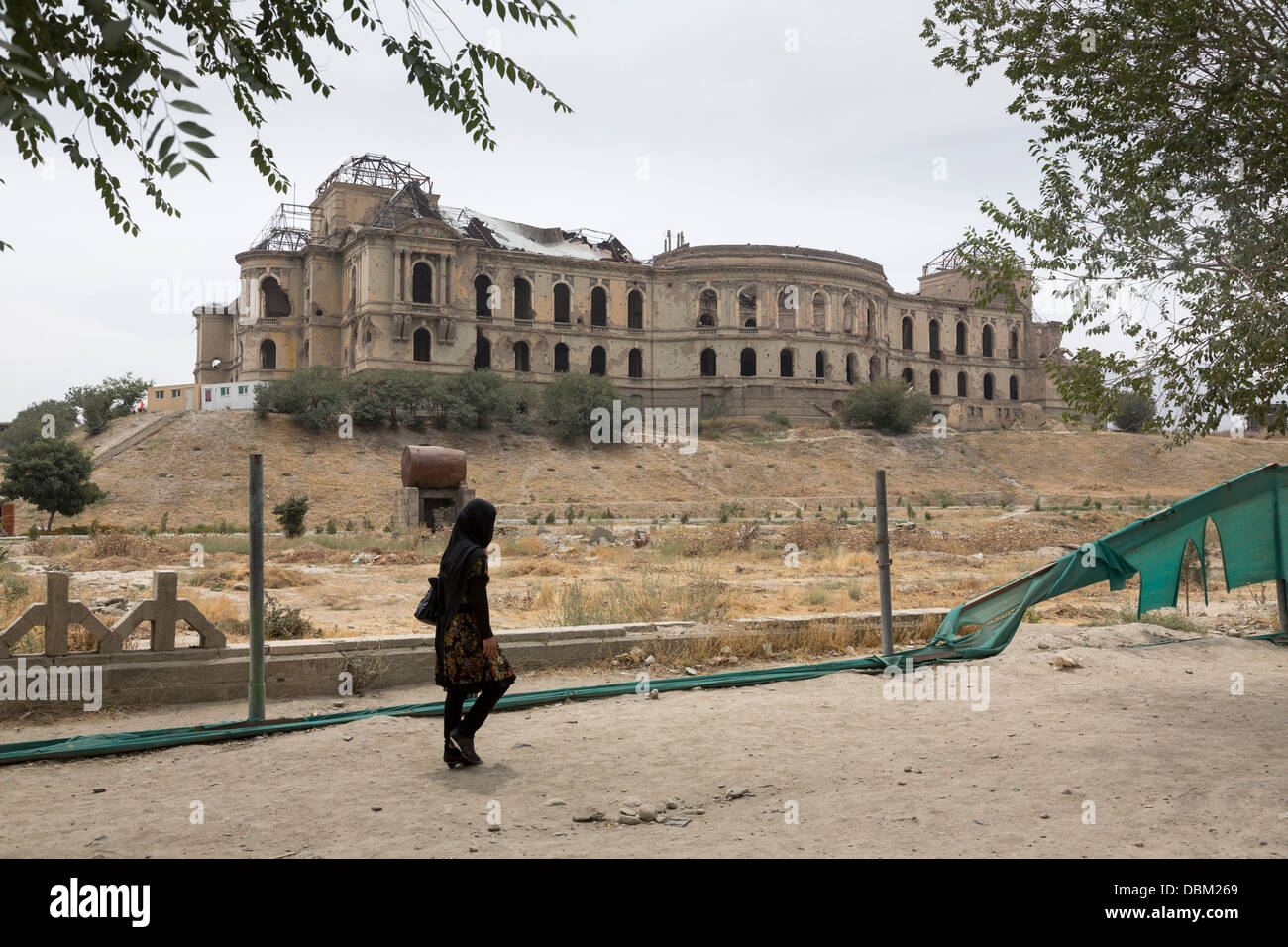 Donna afghana a piedi dalle rovine di Darul Aman Palace, Kabul, Afghanistan Foto Stock