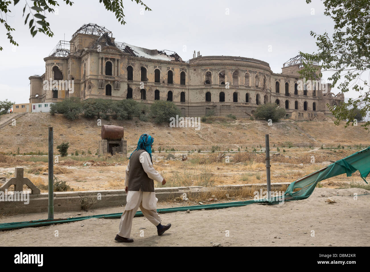 Uomo afgano a piedi dalle rovine di Darul Aman Palace, Kabul, Afghanistan Foto Stock