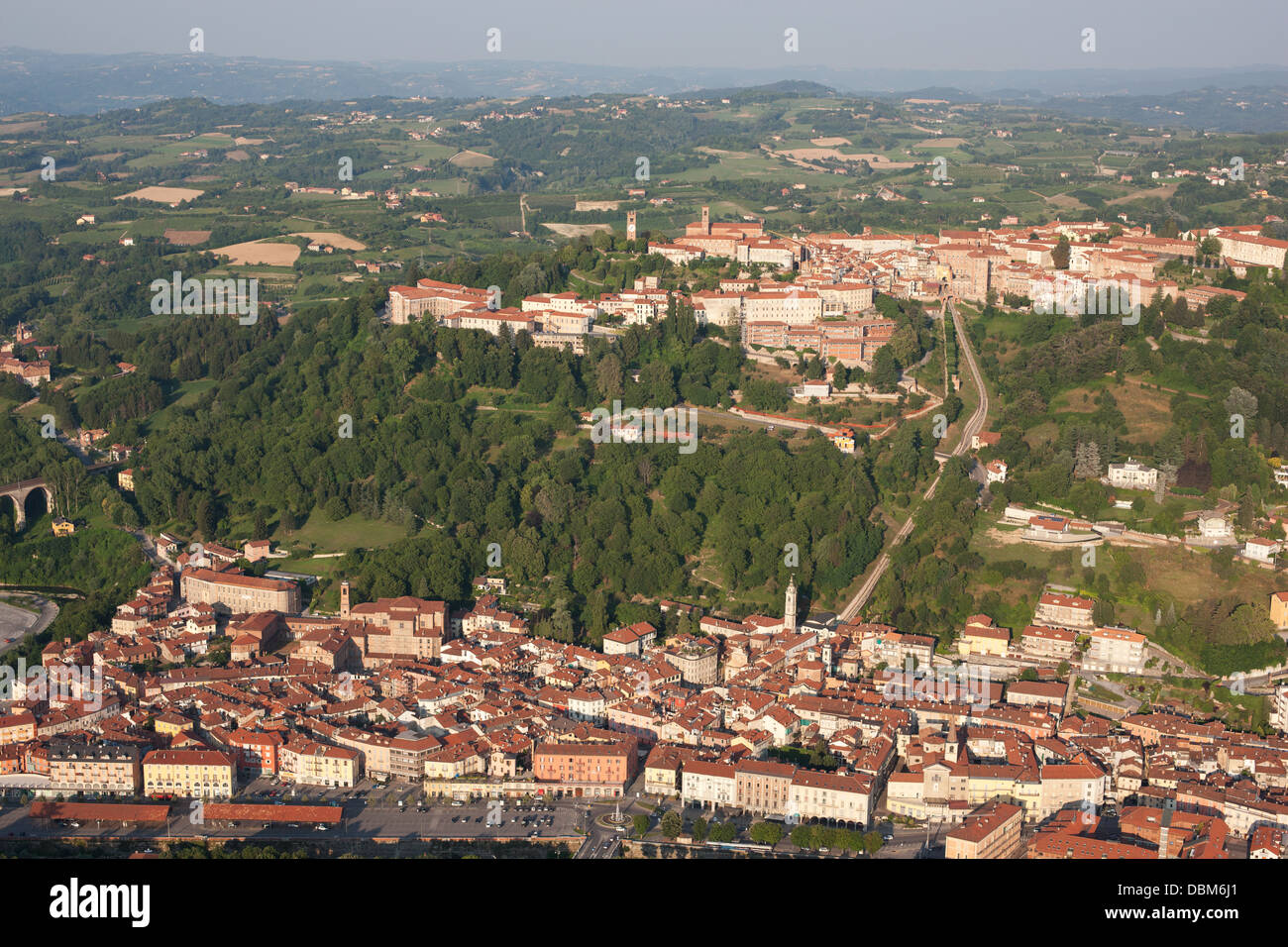 VISTA AEREA. Medievale città in cima alla collina che domina la città più recente ai piedi della collina. Mondovi, Provincia di Cuneo, Piemonte, Italia. Foto Stock