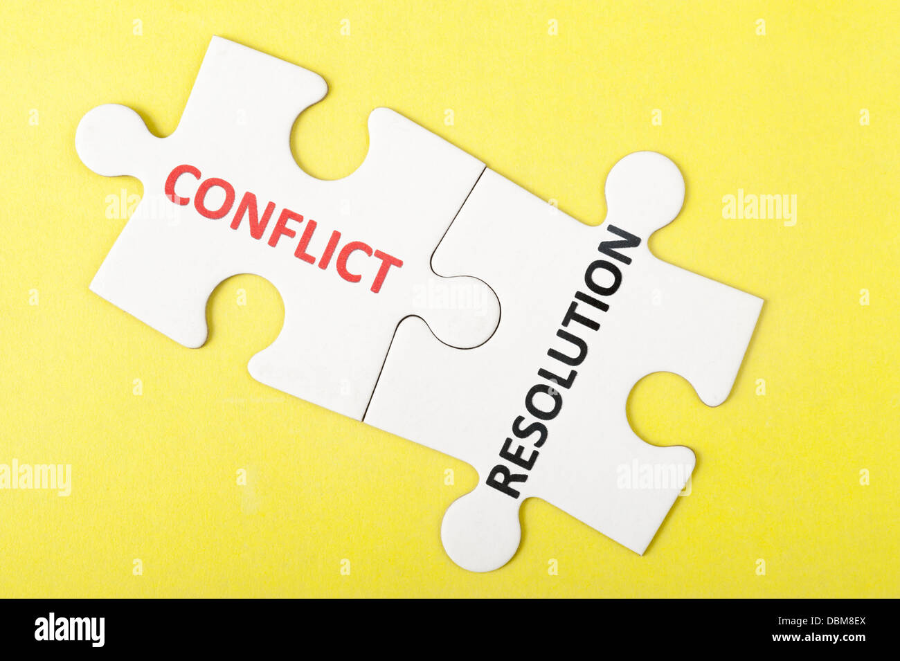 Conflitto e risoluzione parole stampate su due pezzi di un puzzle Foto Stock