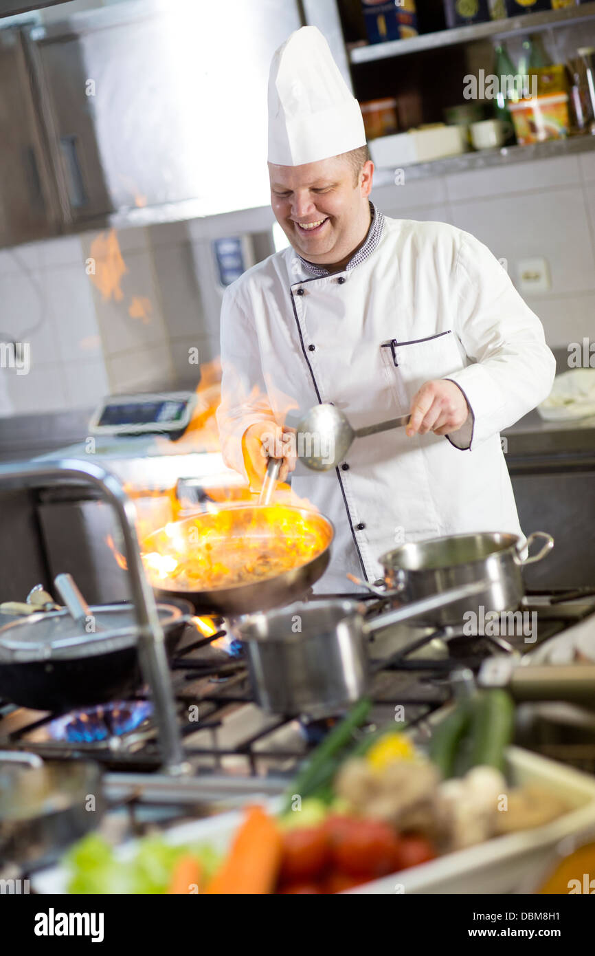 Lo Chef flambeing cibo in padella Foto Stock