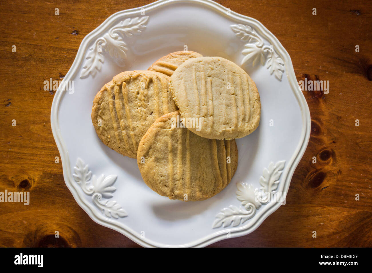 Biscotti fatti in casa al burro di arachidi, appena sfornati e su un piatto bianco, tavolo in legno. STATI UNITI. Foto Stock