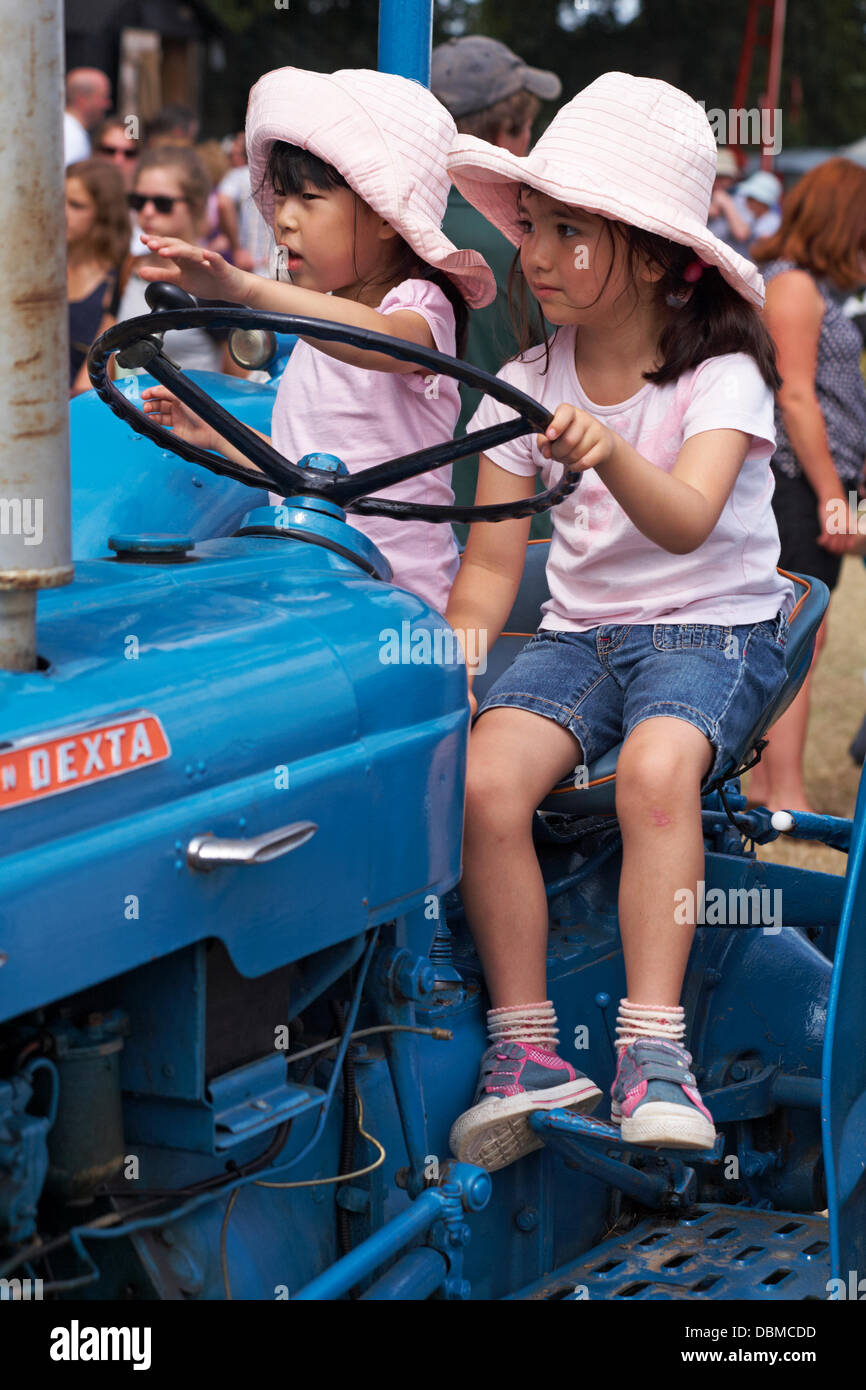 New Forest & Hampshire County Show, vicino Brockenhurst, Hampshire Regno Unito 1 agosto 2013. Migliaia di persone si affollano all'ultimo giorno mentre le temperature salono e il sole splende. Due giovani ragazze che si siedono sul trattore Credit: Carolyn Jenkins/Alamy Live News Foto Stock