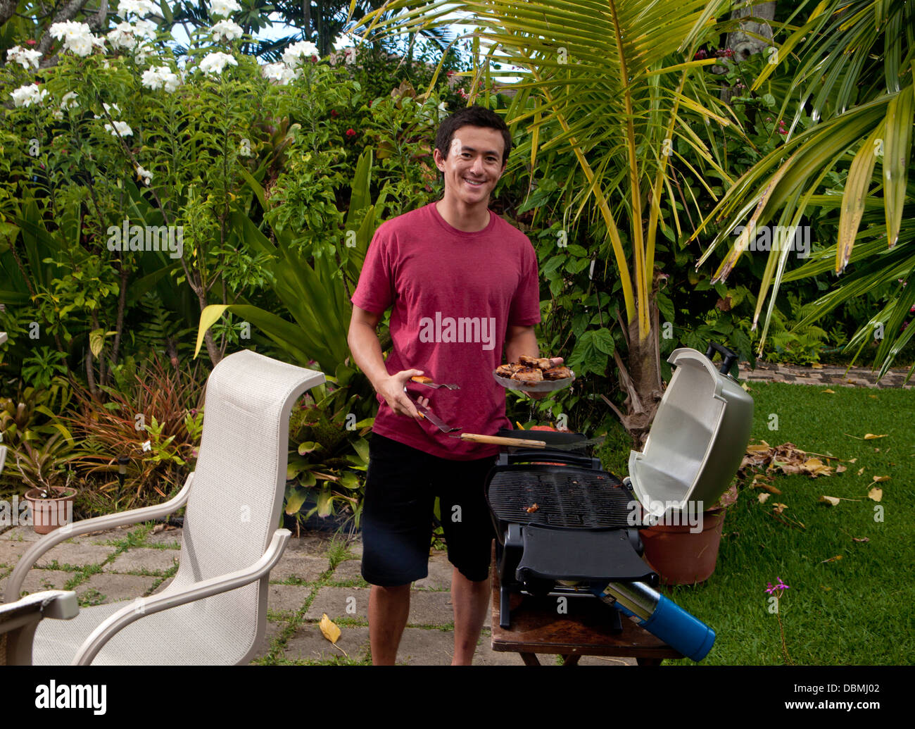 Giovane uomo asiatico cucina pranzo a barbecue Foto Stock