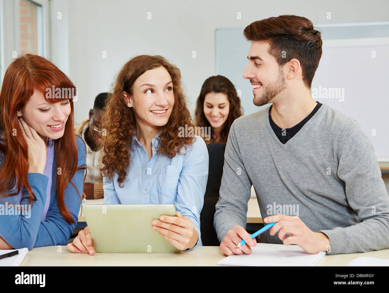 Felice di apprendimento degli studenti con il tablet pc in classe officina Foto Stock