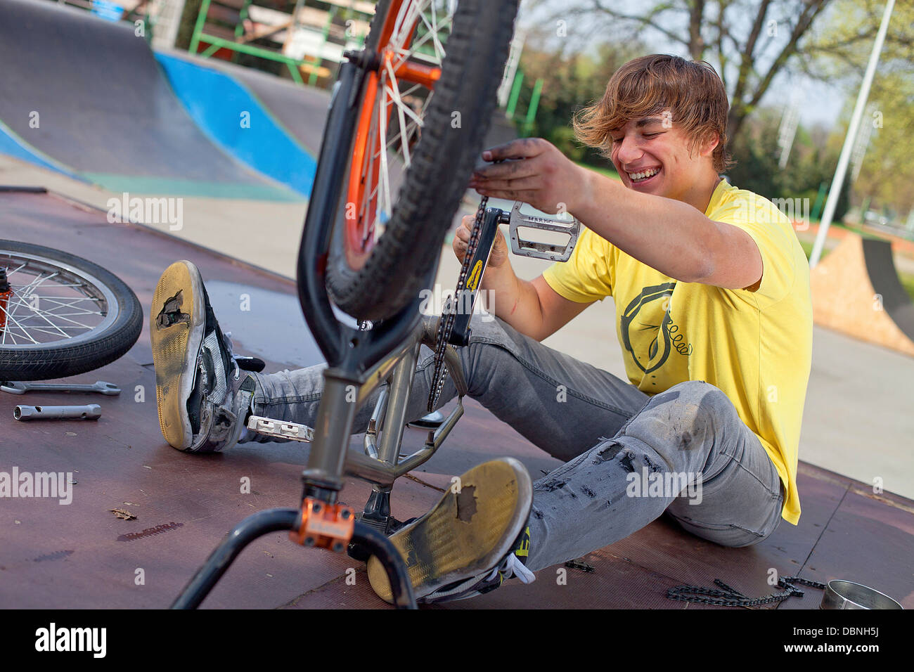 Adolescente facendo lavori di riparazione su BMX bike, osijek, Croazia, Europa Foto Stock