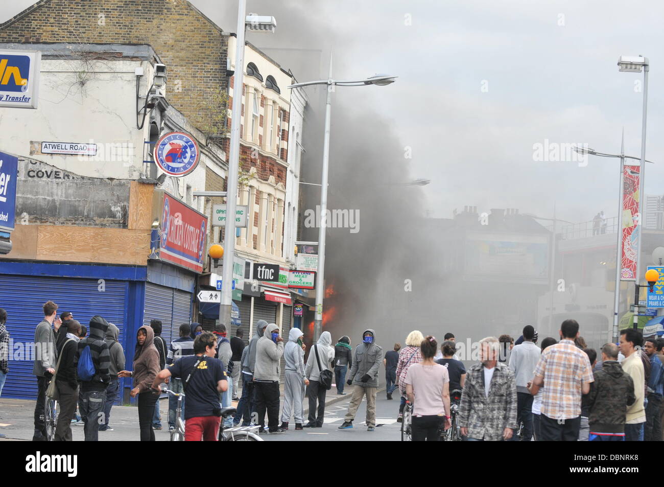 Rivoltosi si radunano vicino a un negozio per bambini che è stato impostato sul fuoco in Peckham, Londra Sud, in Inghilterra il Agosto 8, 2011 scontri e saccheggi hanno rotto in tutto Greater London dopo le riprese di Mark Duggan dalla polizia a Tottenham, Nord di Londra il venerdì Foto Stock