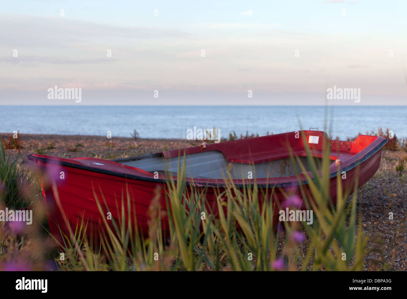 Rosso barca sulla spiaggia di Dunwich nel Suffolk Coast Foto Stock