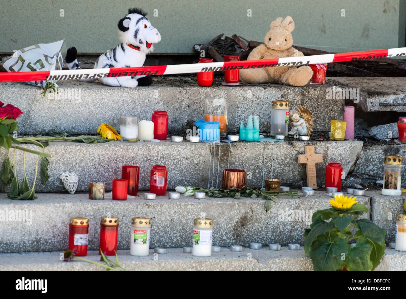 Candele, animali imbalsamati e fiori sono rimasto in un sito dove a cinque anno-vecchia ragazza muore in Regensburg, Germania, 02 agosto 2013. La ragazza è stata uccisa dopo una vettura sportiva inseguito dalle forze di polizia si è schiantato in una lavanderia a gettoni. Foto: ARMIN WEIGEL Foto Stock