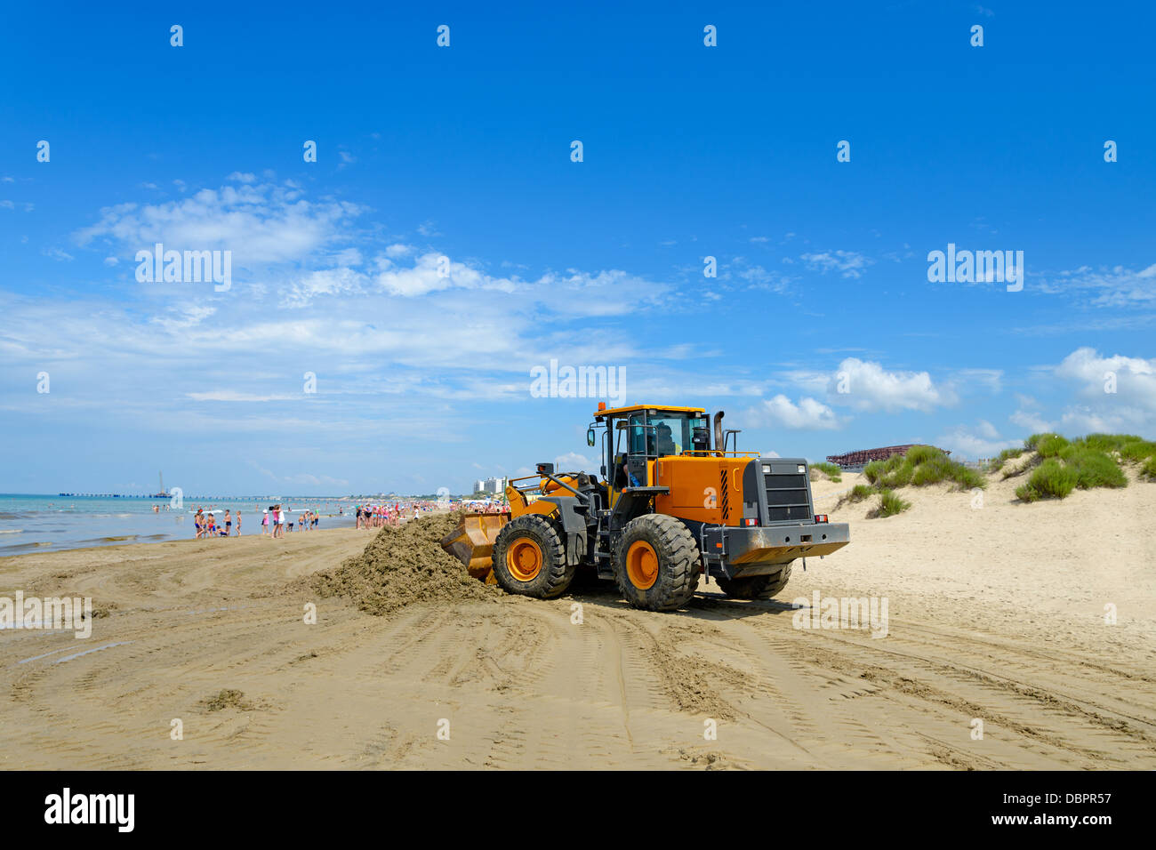 Il bulldozer pulisce lo sporco su una spiaggia dopo una tempesta Foto Stock