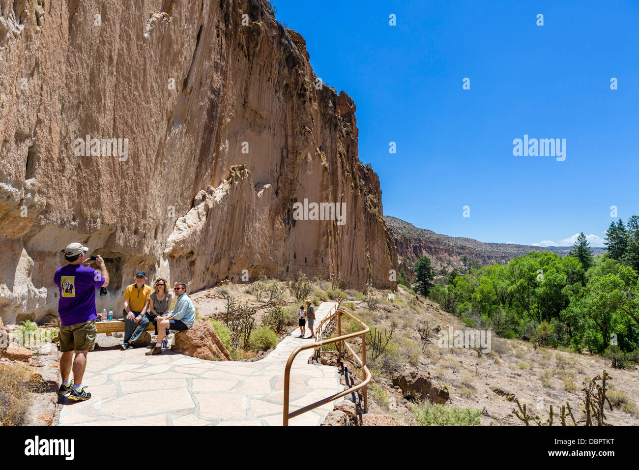 I turisti di fronte alla casa lunga, Pueblo cliff dwellings al Bandelier National Monument, vicino a Los Alamos, Nuovo Messico, STATI UNITI D'AMERICA Foto Stock