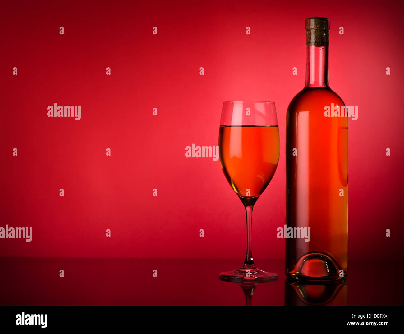 Buttle e bicchiere di vino bianco su uno sfondo rosso Foto Stock