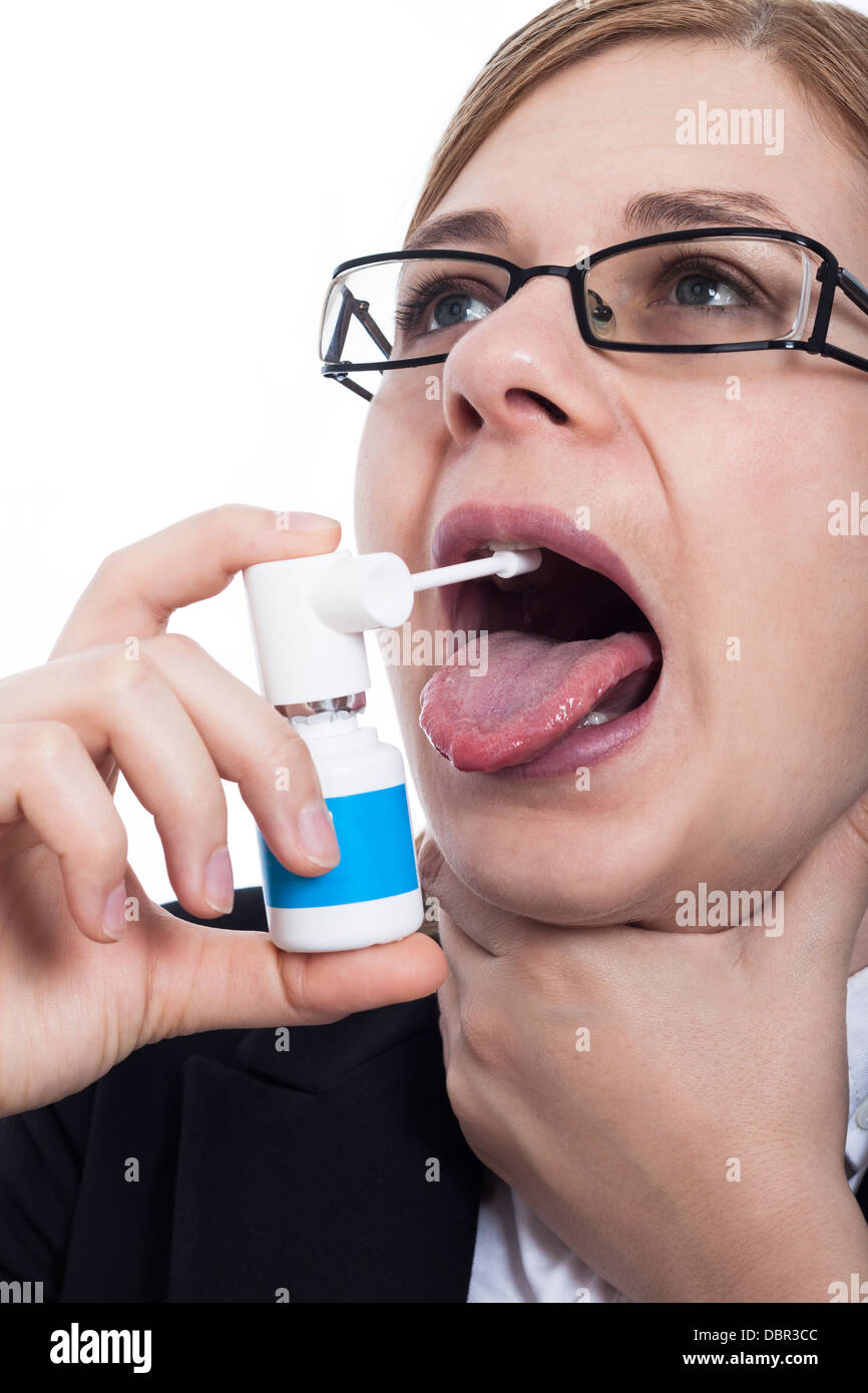 Primo piano della donna con gola dolore utilizzando spray orale, isolato su sfondo bianco. Foto Stock