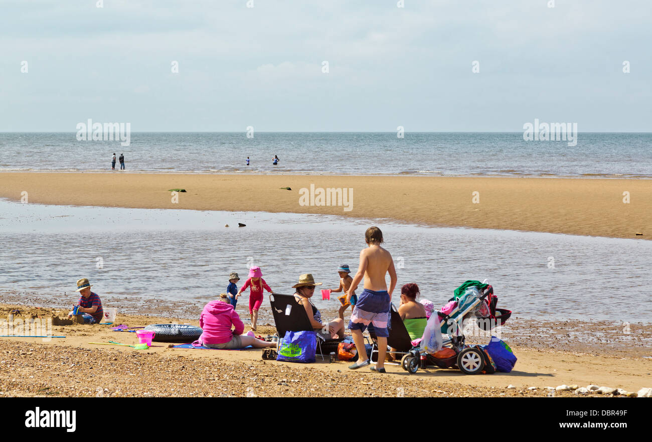 Vacanza con la famiglia in una giornata di sole a Hunstanton Beach, Norfolk, Inghilterra Foto Stock