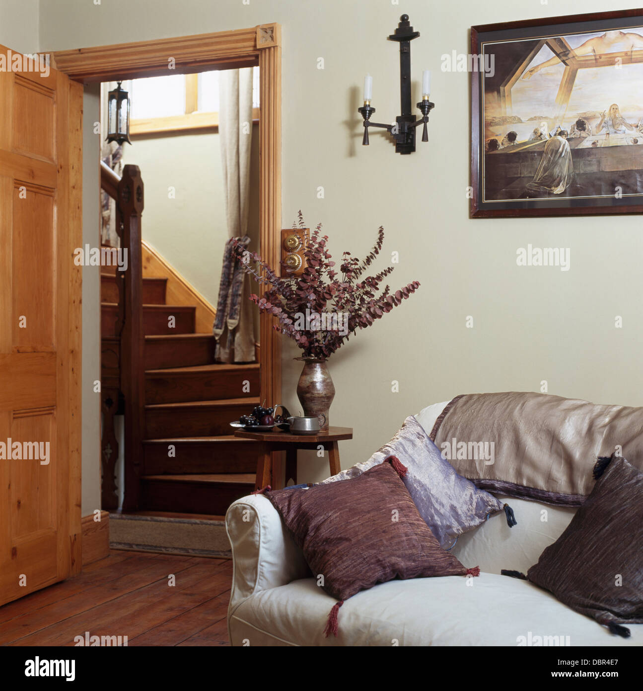 Cuscini di seta sul divano bianco in cottage soggiorno con porta aperta al  salone con scala in legno Foto stock - Alamy