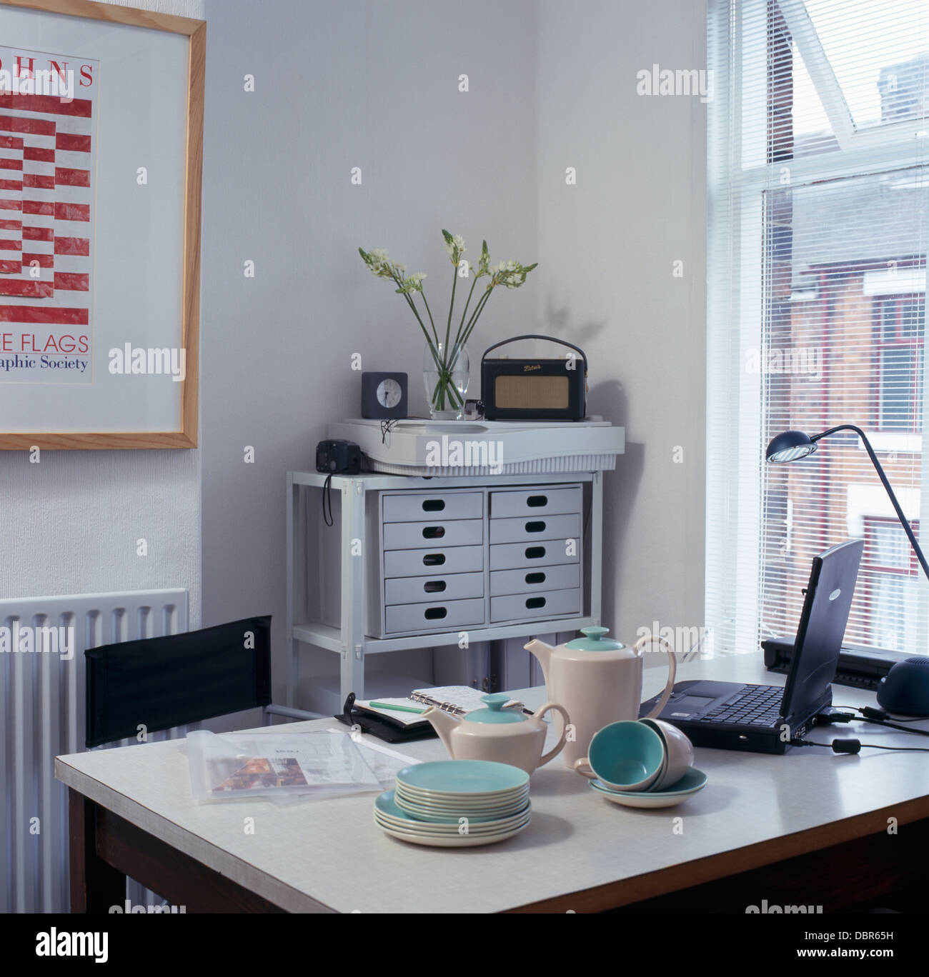 Negli anni cinquanta beige+turchese caffè e tè set sul tavolo con il computer portatile in studio sala da pranzo con Roberts radio sul piccolo Filing cabinet Foto Stock