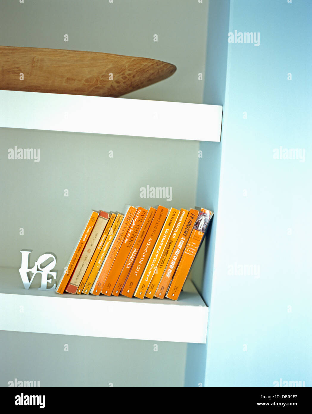 Close-up di un insieme di vecchio pinguino libri sugli scaffali con metallo 'amore' ornamento Foto Stock