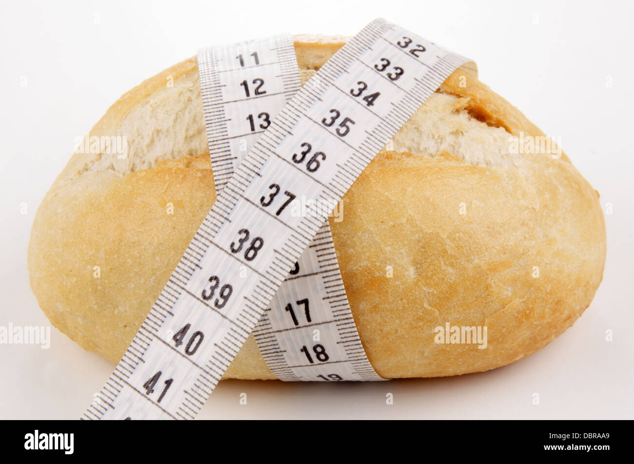 Rotolo di pane con un centimetro di nastro di misurazione Foto Stock
