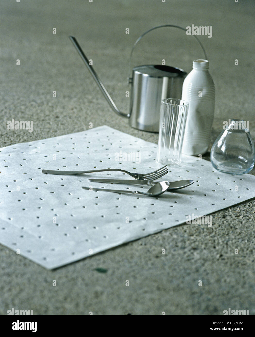 Close-up di piccoli in acciaio inossidabile olio di oliva può essere colata e posate sul tappeto bianco con vasi in vetro Foto Stock