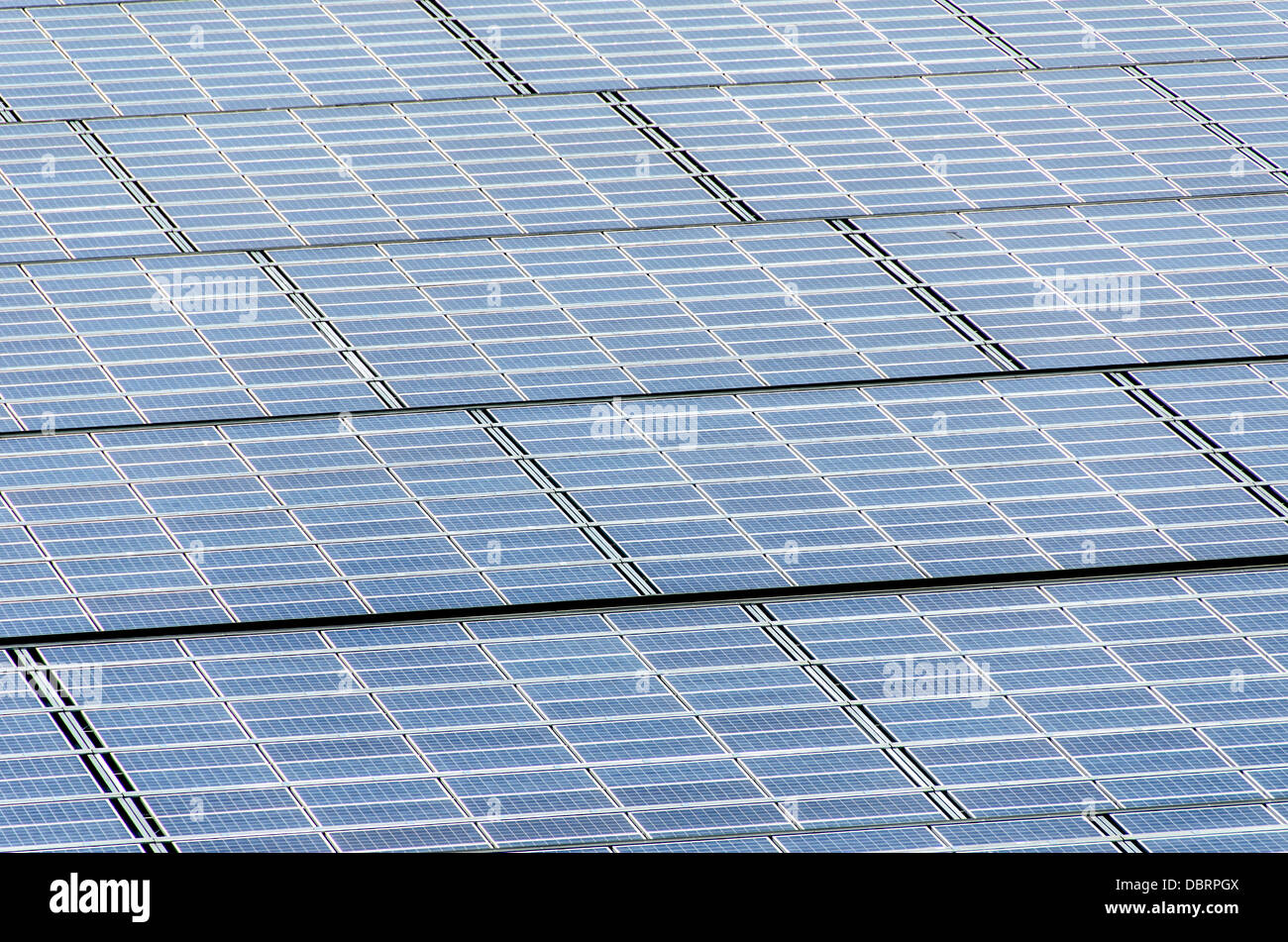 Solar Panels Photovoltaic Array // una vasta gamma di pannelli fotovoltaici solari risplende sotto la luce solare intensa, mostrando l'impressionante scala delle moderne installazioni di energia solare. Questi pannelli disposti con precisione convertono in modo efficiente le abbondanti radiazioni solari in energia elettrica pulita e rinnovabile, esemplificando il ruolo crescente delle tecnologie sostenibili nel soddisfare le esigenze energetiche globali. Foto Stock Solar Panels Photovoltaic Array // una vasta gamma di pannelli fotovoltaici solari risplende sotto la luce solare intensa, mostrando l'impressionante scala delle moderne installazioni di energia solare. Questi pannelli disposti con precisione convertono in modo efficiente le abbondanti radiazioni solari in energia elettrica pulita e rinnovabile, esemplificando il ruolo crescente delle tecnologie sostenibili nel soddisfare le esigenze energetiche globali. Foto Stock