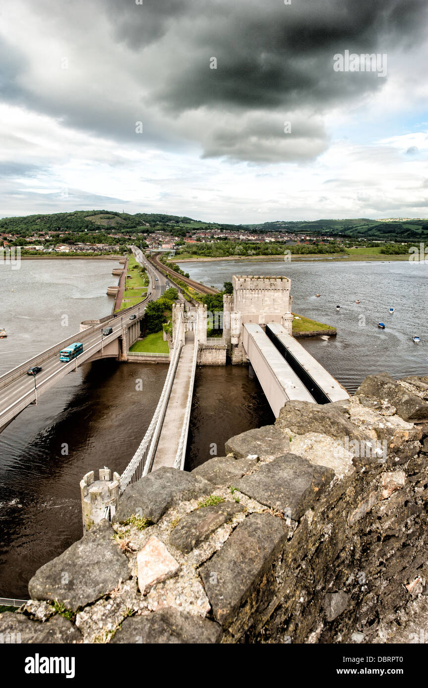 CONWY, Galles - Conwy Road Bridge attraversa il fiume Conwy visto da una torre del castello di Conwy. La fortezza medievale fu costruita da Edoardo i durante la sua conquista del Galles alla fine del XIII secolo e forma parte della città fortificata di Conwy. Il castello occupa una posizione strategica sull'estuario del fiume Conwy nel Galles del Nord. Il castello di Conwy è stato dichiarato Patrimonio dell'Umanità dall'UNESCO come parte dei castelli e delle mura cittadine di re Edoardo nel Gwynedd. Il ponte collega il centro storico della città con la regione circostante attraverso le acque mareali del fiume Conwy. Foto Stock