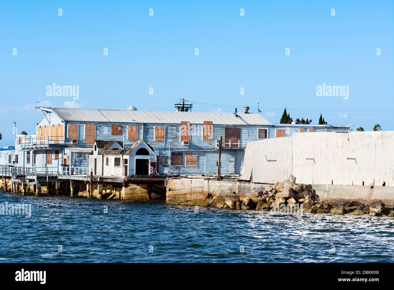 Un vecchio, abbandonato waterfront magazzino con imbarcati su windows e peeling, legno marcescente a San Pedro in California Foto Stock