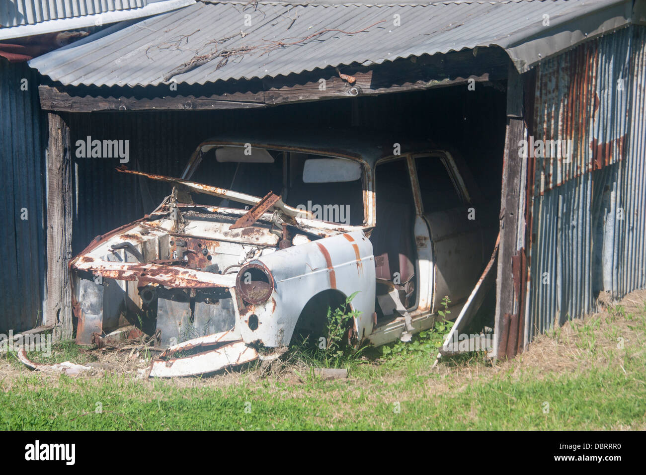 Sgangherate rovinato scatafascio vecchia auto nel vecchio ferro corrugato tin shack garage Newcastle New South Wales NSW Australia Foto Stock