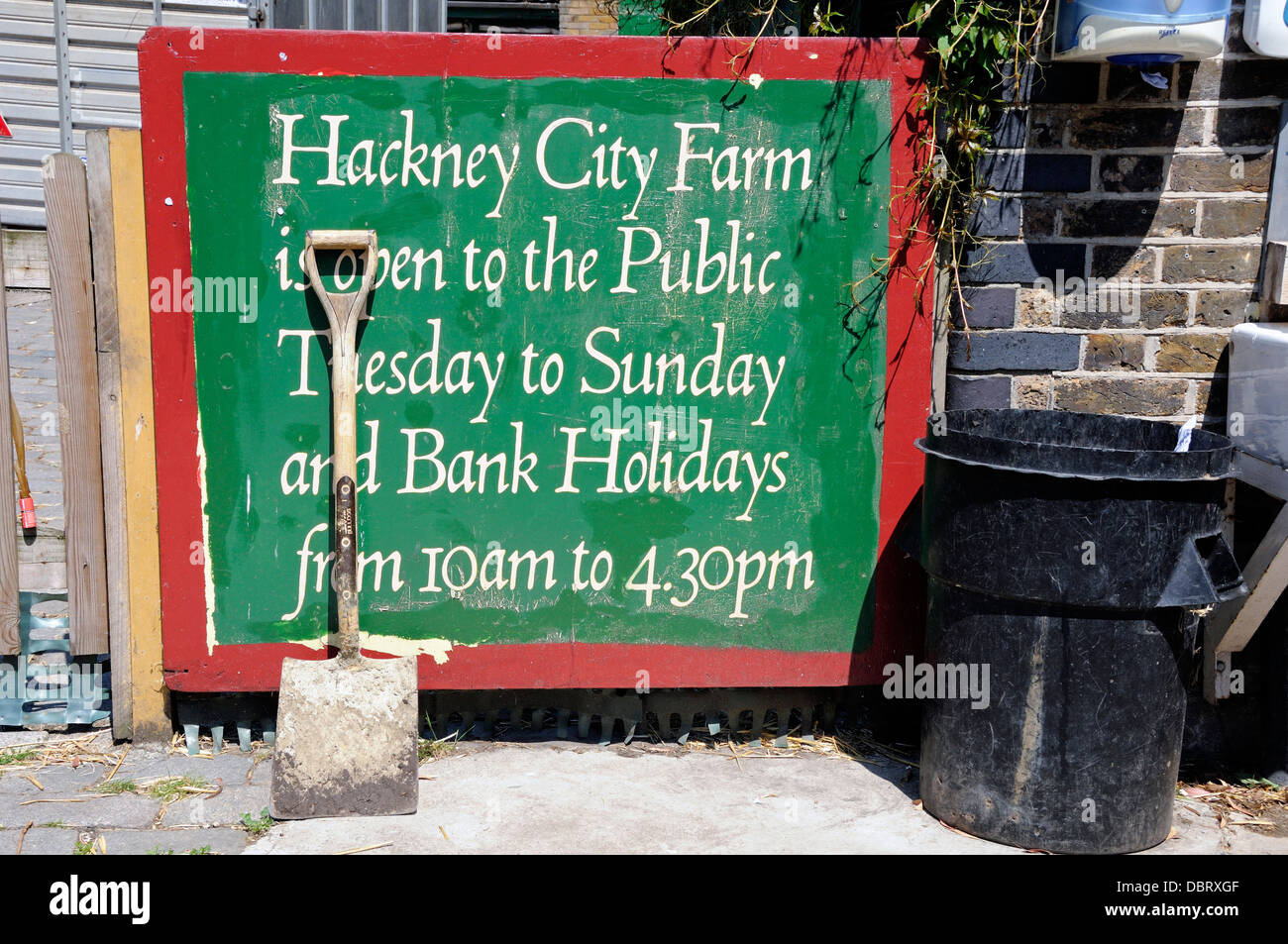 Spade appoggiato a Hackney City Farm di firmare o di avviso, London Borough of Hackney, England, Regno Unito Foto Stock