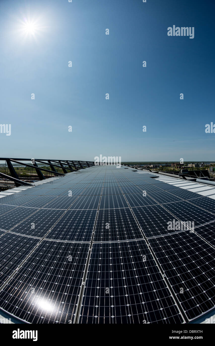 Una schiera di pannelli solari fotovoltaici utilizzati per convertire la luce solare in energia elettrica in condizioni di luce solare intensa. Foto Stock