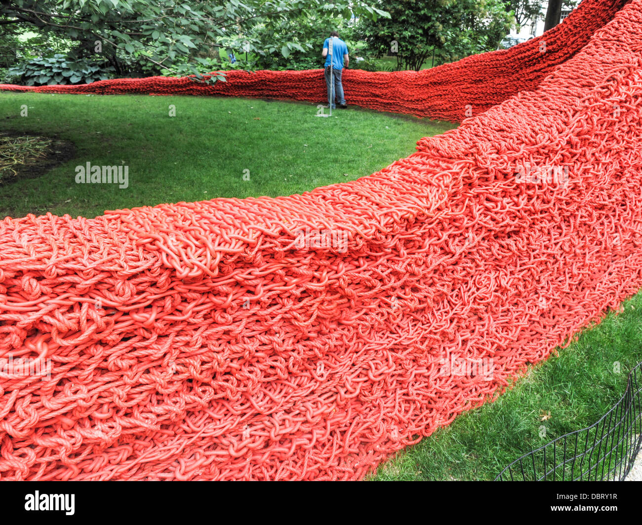 Lavoratore che fa il lavoro di manutenzione sul sinuoso corda di tessuto arte di installazione rosso giallo blu da Orly Genger Madison Square Park di New York Foto Stock
