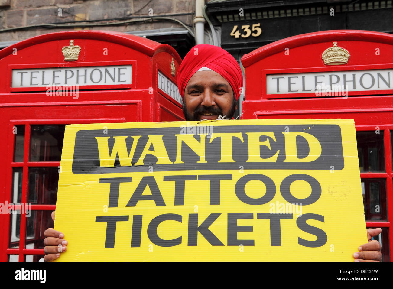 Un uomo Sikh sul Royal Mile di Edimburgo, in Scozia. Egli è il tentativo di acquistare i biglietti per la Edinburgh Tattoo. Foto Stock