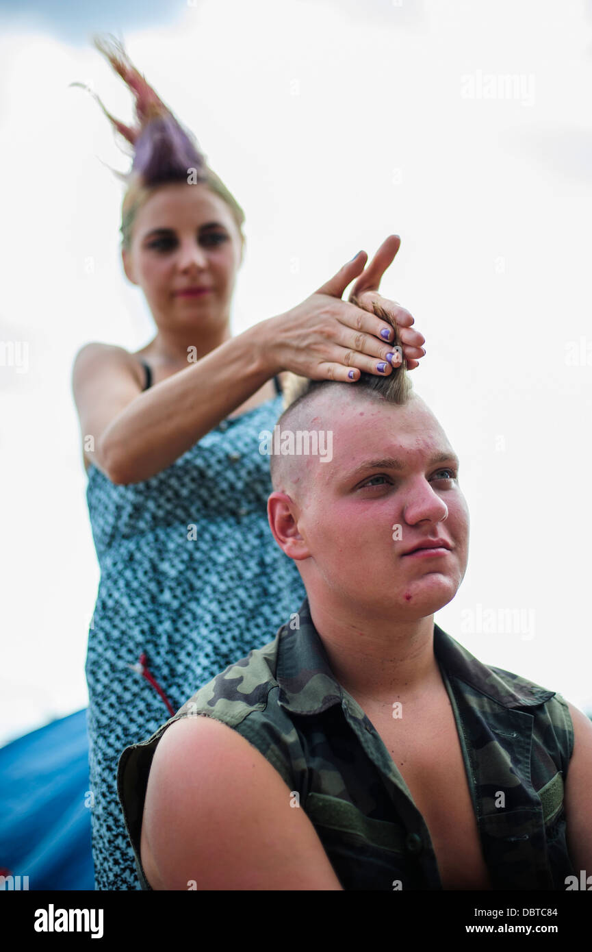 Un partecipante al festival di ottenere il suo taglio di capelli punk fatto durante il Przystanek Woodstock music festival, Kostrzyn, Polonia. Foto Stock