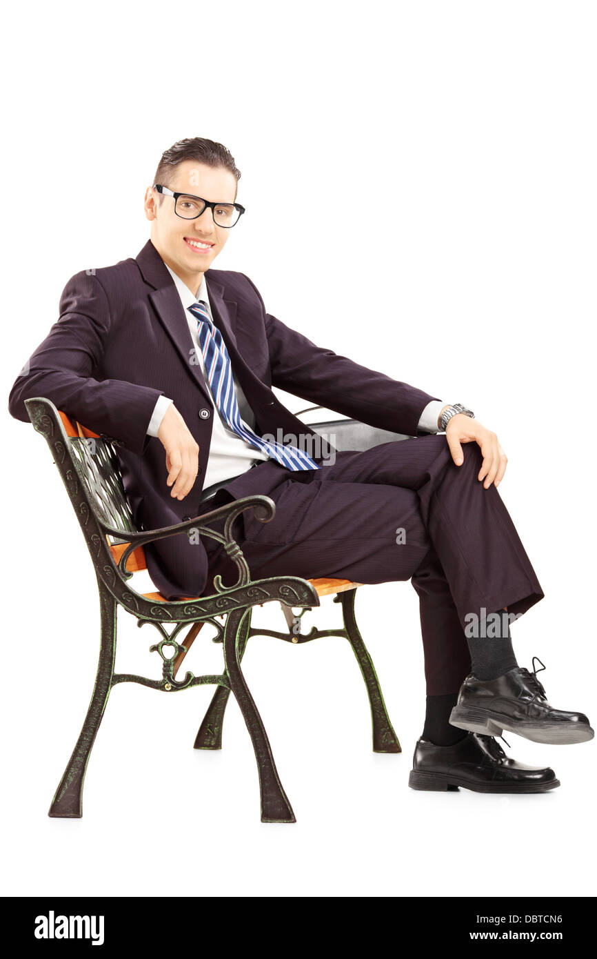 Sorridente giovane uomo in una tuta seduta su una panchina Foto Stock