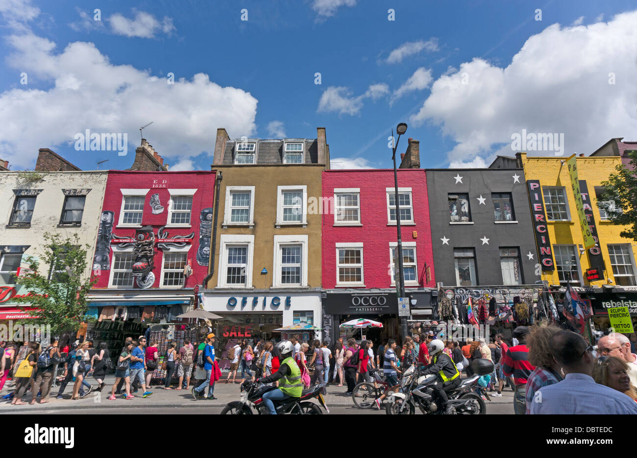 Una coloratissima sfilata di shopping in estate il sole, su una trafficata Camden High Street, vicino a Camden Market, Londra, Inghilterra, Regno Unito. Foto Stock